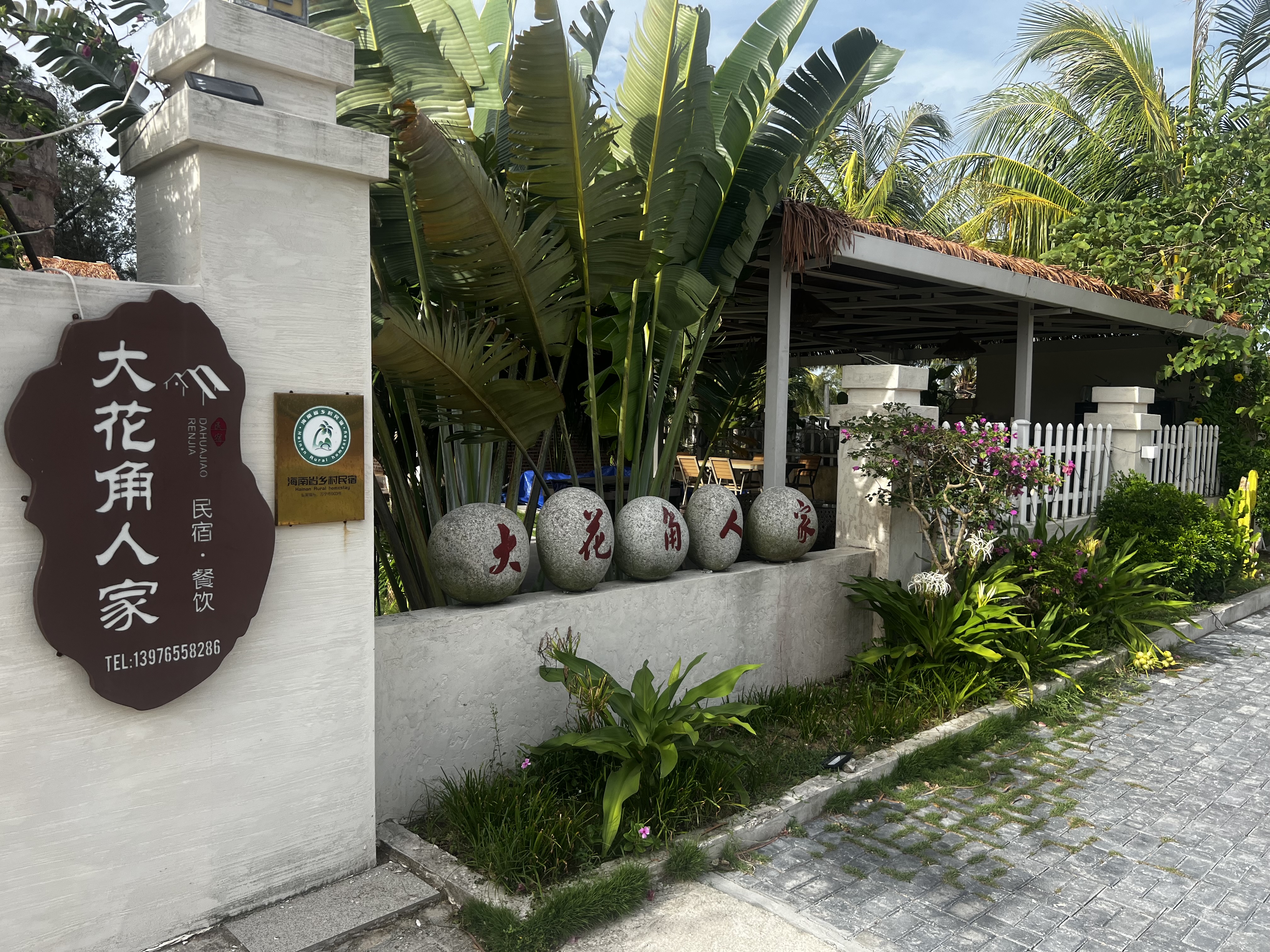 Entrance with sign showing Dahuajiao Renjia name, contact and homestay certification