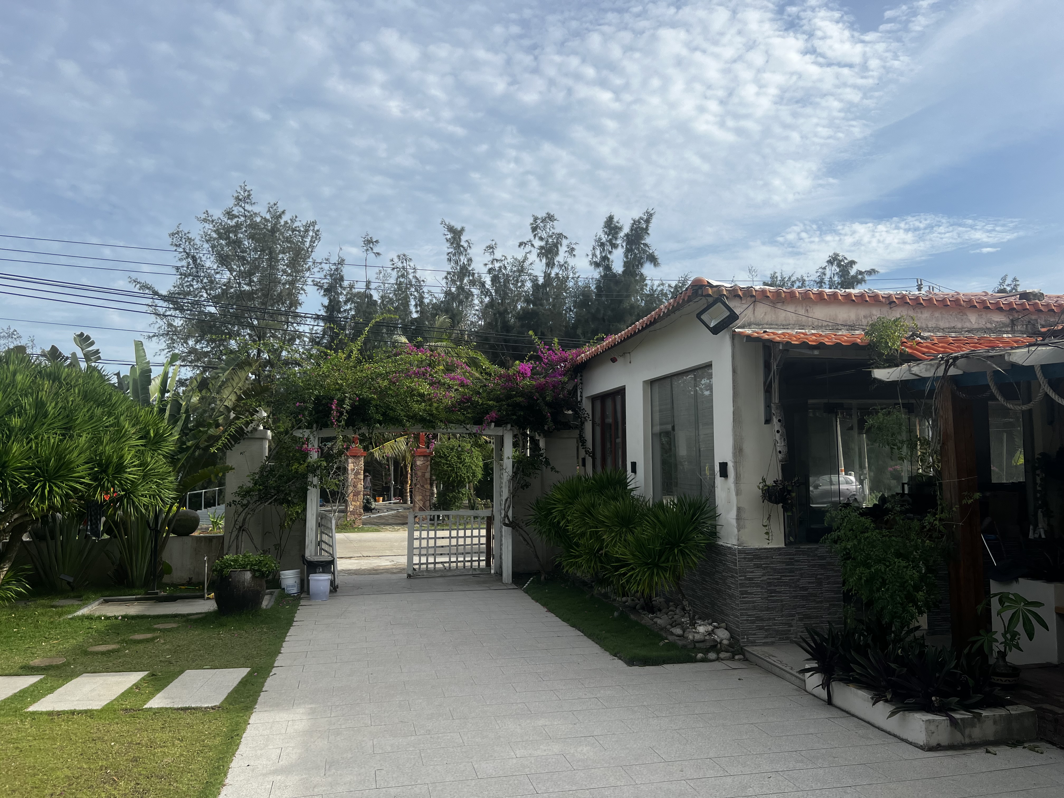 Garden pathway with tropical plants and traditional architecture