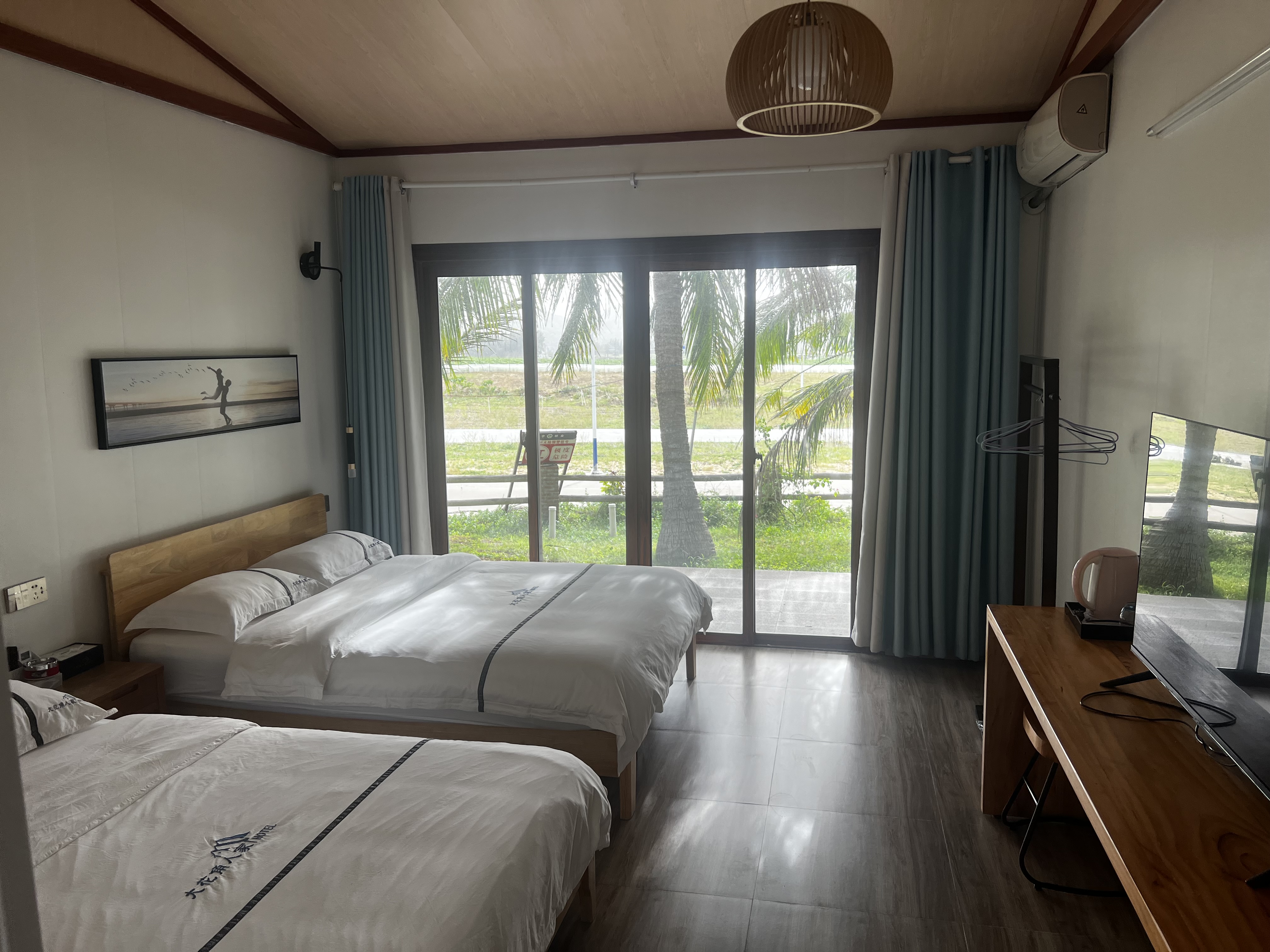 Guest room with twin beds, tropical view window, TV and modern amenities
