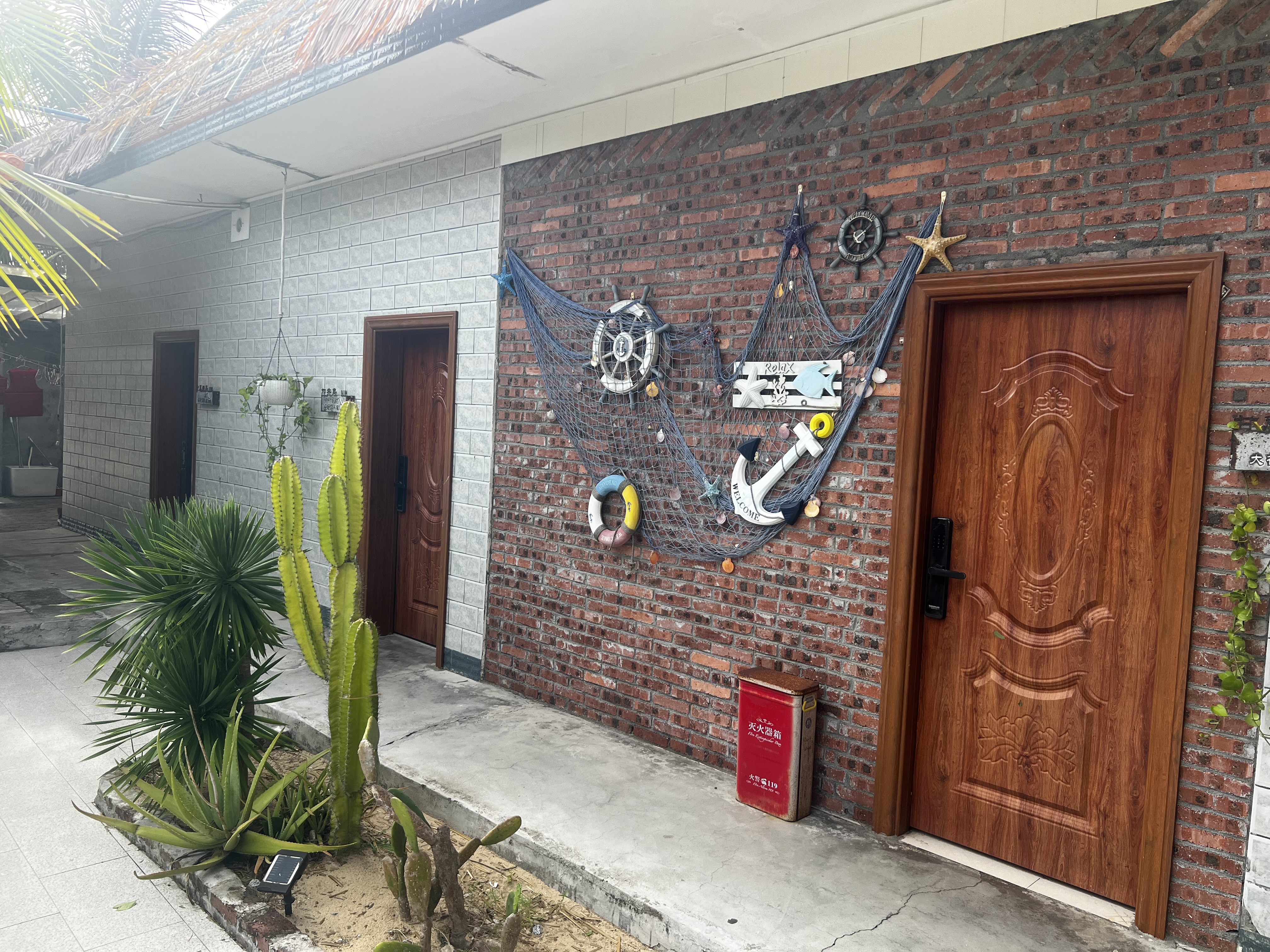 Brick guest cottage with nautical-themed wall decor and wooden doors